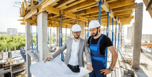 two construction workers and surveyor on construction site